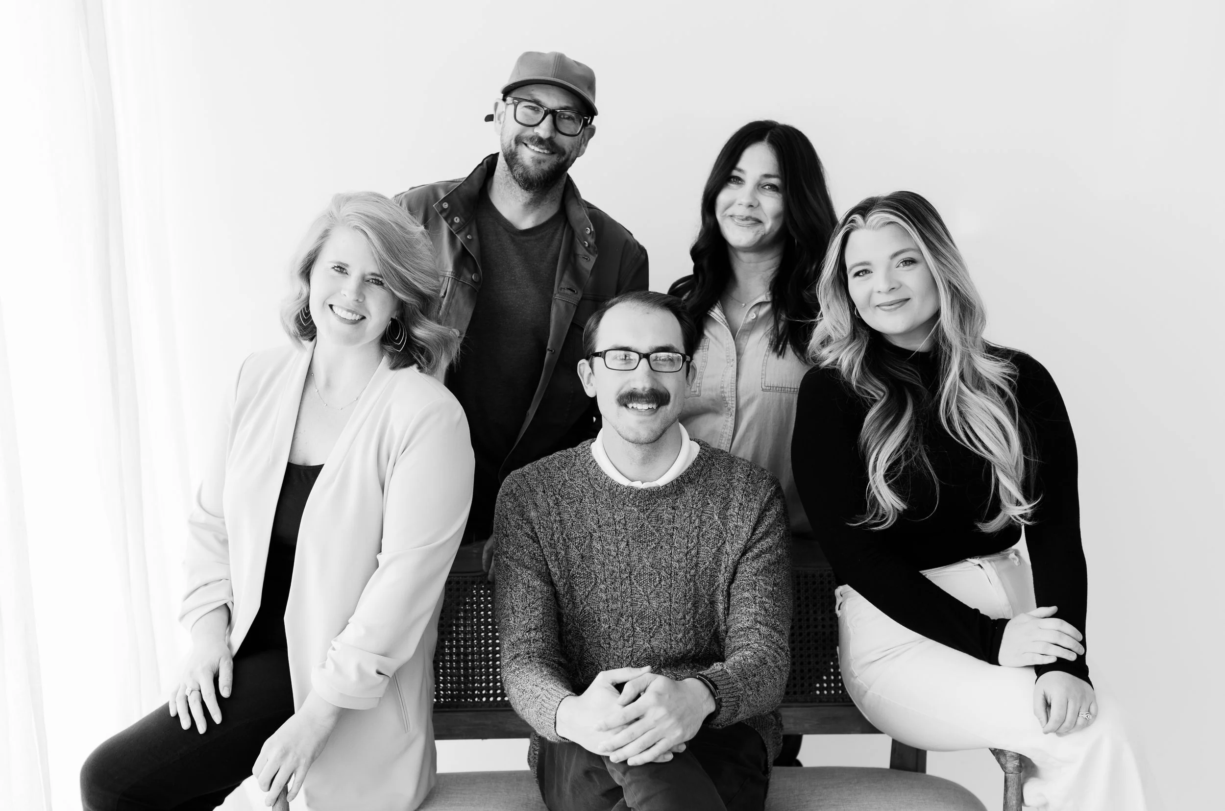 The five photographers of Kim Box Photography together in the studio, photographed in black and white